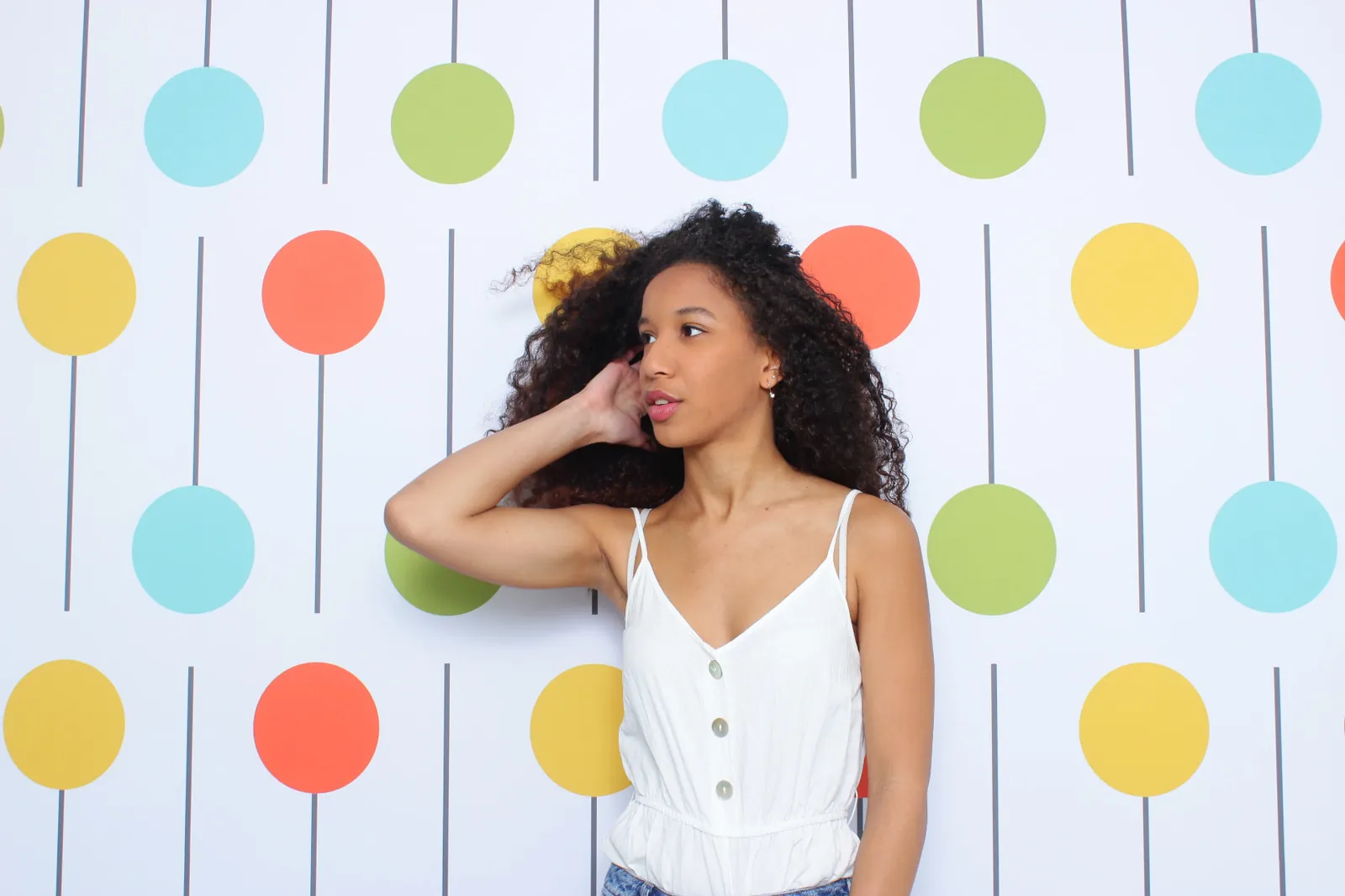 Attendee posing in front of a colorful branded photo booth backdrop at a trade show