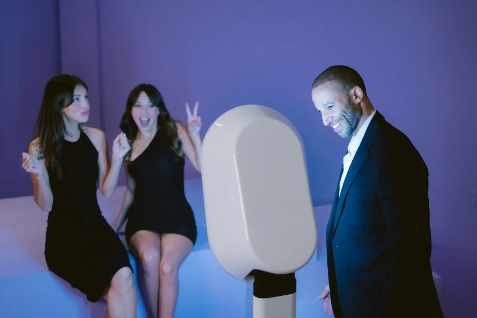 Colleagues in formal attire laughing at a corporate event photo booth in Boston